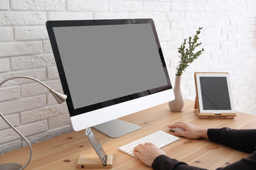 Fototapeta premium Young man using modern computer at table, closeup