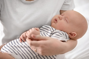 Mother holding her little baby on light background