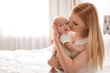 Mother with her little baby in bedroom