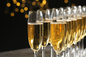 Glasses of champagne against blurred lights, closeup. Bokeh effect