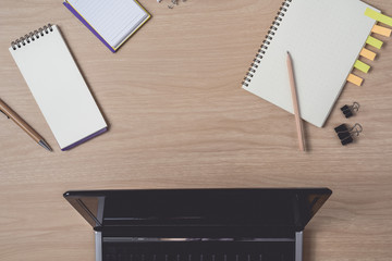 Workspace with diary or notebook and clipboard, laptop, pencil, pen, sticky notes on wooden background