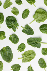 Naklejka na ściany i meble Fresh leaves of spinach isolated on white, top view