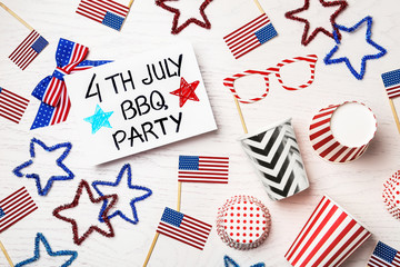Fototapeta premium Flat lay composition with card and decorations on wooden table. USA Independence Day