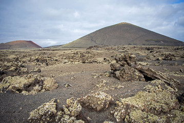 Fototapeta na wymiar Paesaggio vulcanico con la montagna Colorada sullo sfondo, isola di Lanzarote, parco nazionale Timanfaya 