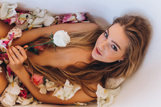 Photo session of a young girl in a bathroom with a white rose in her hand.