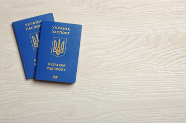 Ukrainian travel passports on wooden background, top view with space for text. International relationships