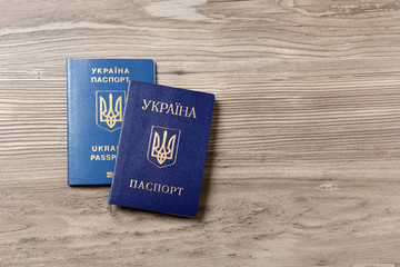 Ukrainian passports on wooden background, top view with space for text. International relationships