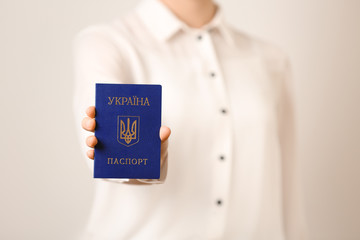 Woman holding Ukrainian internal passport on light background, closeup