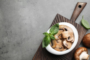 Flat lay composition with delicious cooked mushrooms on table, space for text