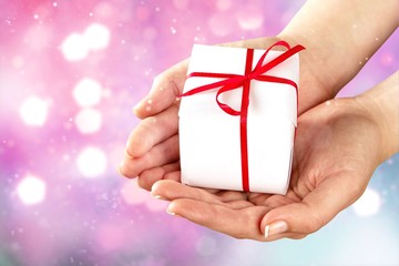 Human hands holding Little christmas box with bow isolated on  background