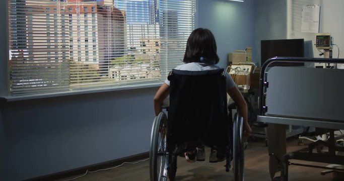 Female patient sitting in wheelchair in hospital