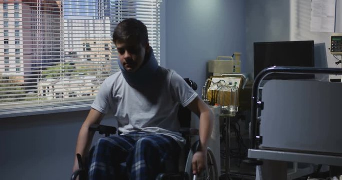 Teenager patient sitting in wheelchair in hospital