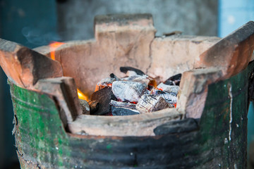 Thai stove, cooking tool. Traditional charcoal burning clay stove in a rustic wooden house.