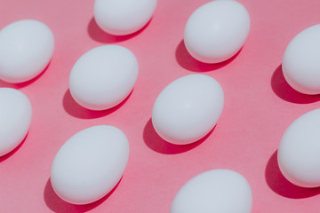 White chicken eggs  with empty space, on a pink background. Abstract image