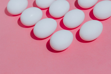 White chicken eggs  with empty space, on a pink background. Abstract image