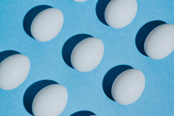 White chicken eggs  with empty space, on a blue background. Abstract image