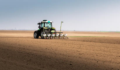 Obraz premium Farmer with tractor seeding soy crops at agricultural field