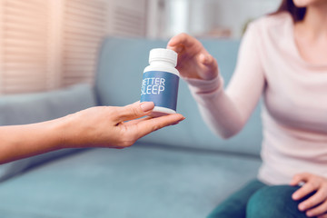 Close-up photo of the process of handing a bottle