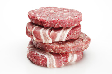 Raw meat patties for burgers on a white background.