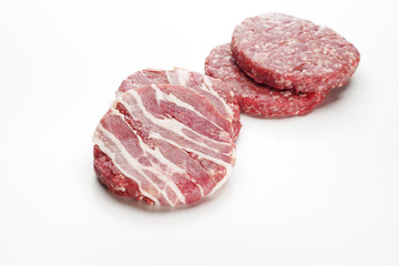 Raw meat patties for burgers on a white background.