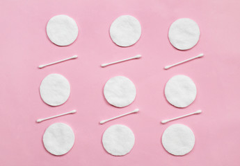 Obraz na płótnie Canvas Top view of cotton pads and buds on pink background