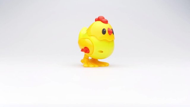 Clockwork chick toy hopping around. Slow motion.