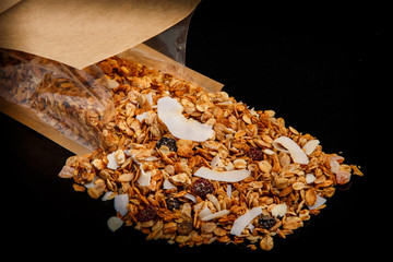 closeup muesli with dried coconut and raisins fell out from open craft bag