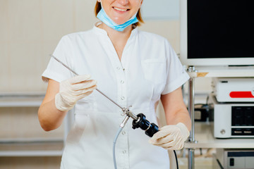 Close up of happy female surgeon in protective wear uniform, medical gloves hysteroscope for...