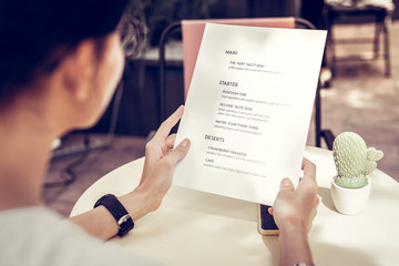 Close up of a menu being in female hands - obrazy, fototapety, plakaty