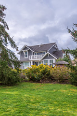 Beautiful exterior of newly built luxury home. Yard with green grass and walkway lead to front entrance.
