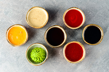 Different tasty sauces in bowls on grey background