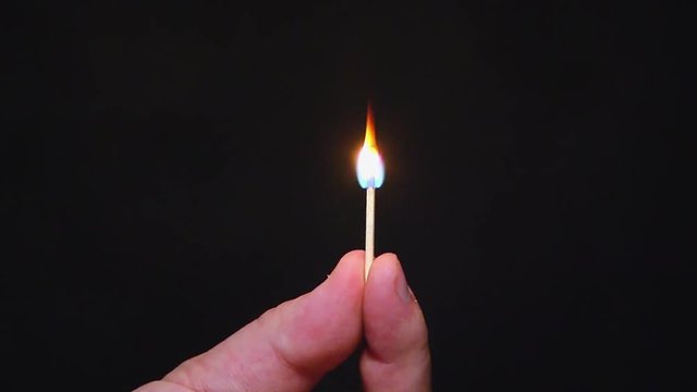 burning match on a dark background