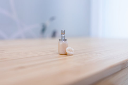 Dentist tools and tooth on wooden table in dental clinic with bokeh