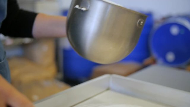 Marshmallow Mastic Is Transferred From Bowl Into The Stove By The Spatulaю Close up hand held slow motion shot as chef transfers white mastic from a bowl into the stove by spatula in the professional 