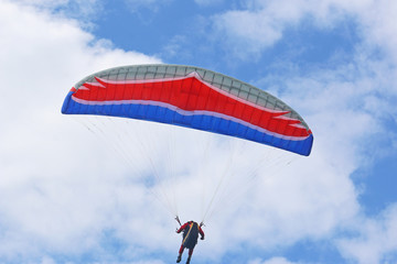 Paraglider flying red wing