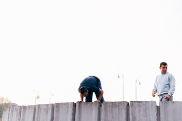 Caucasian man trains parkour while jumping over a high top.