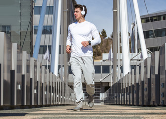 Handsome fit sportsman running fast over the bridge