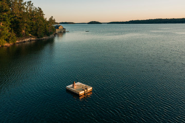 Woman on dock on lake, Muskoka, Canada