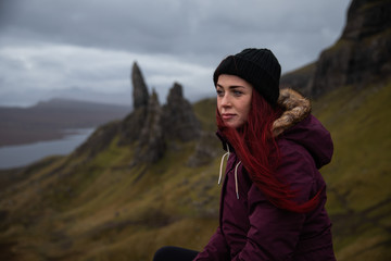 Young woman looking at The Storr, Isle of Skye, Scotland, UK