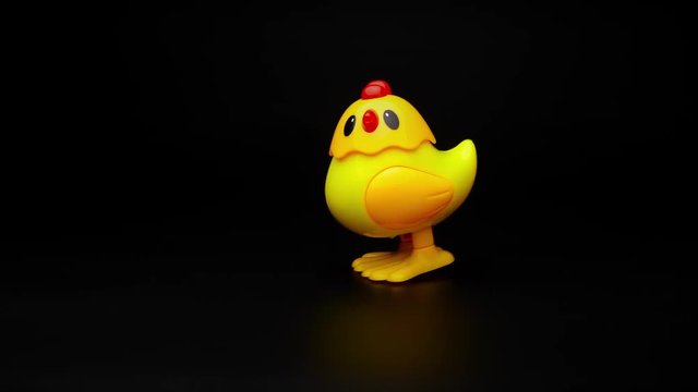 Clockwork yellow toy chicken. Clockwork chick toy hopping around. 