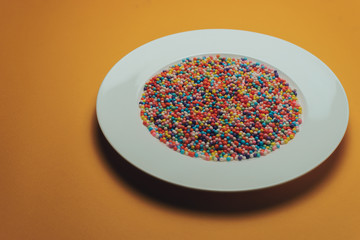 White plate with color preparations (vitamins, dyes, flavor enhancers, nutritional supplements,...