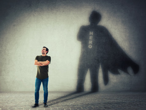 man casting a superhero with cape shadow on the wall