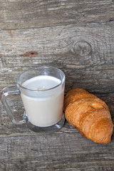 French breakfast with croissant and cappuccino over wooden background