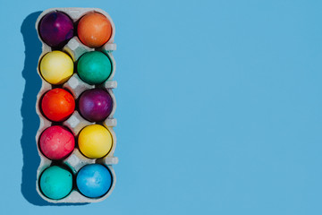 Easter background with Easter eggs. Top view with copy space. multicolored Easter eggs on a blue background