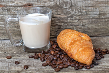 French breakfast with croissant and cappuccino over wooden background
