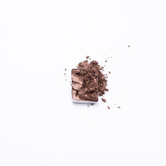 Deep brown crumbled eye shadow isolated on white background.