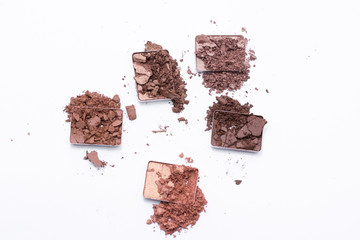 Deep brown crumbled eye shadow isolated on white background.