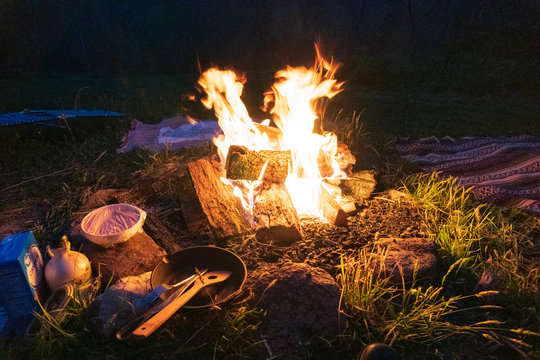 Bushcraft Campfire, Cast Iron Skillet, Camp Blankets And Spatula At Night. Pristine Bon Fire Cooking In The Blue Ridge Mountains In Asheville, North Carolina. 