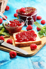 Toast bread with homemade raspberry jam or marmalade on table served with butter for breakfast or brunch