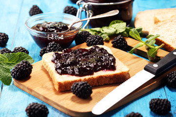 Toast bread with homemade blackberry jam or marmalade on table served with butter for breakfast or brunch